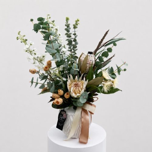 Artificial Flower Arrangement Nora with neutral white and brown native-inspired flowers and dusty eucalyptus in a ceramic vase by Desflora